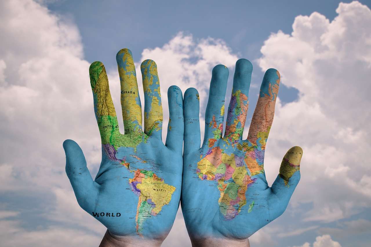 Double Taxation A pair of hands painted with a map of the world